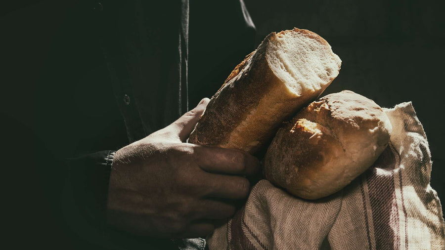 Durchgebrochenes Brot und Händen eines Mannes