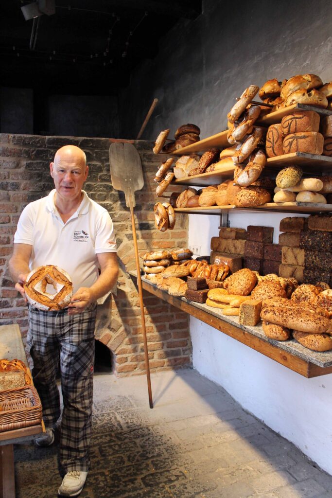 Jörg Terjung der Besitzer des Cafe Reitstalls hält Brot aus dem originale Holzofen