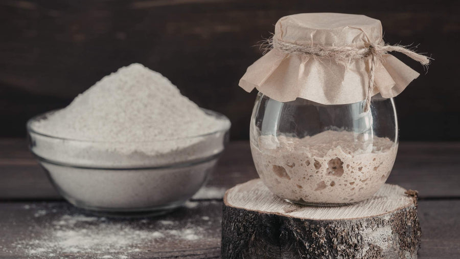 Sauerteig und Mehl im Hintergrund