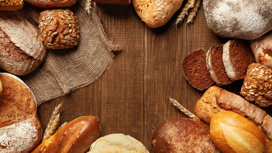 Verschiedene Brote liegen auf einem Holztisch