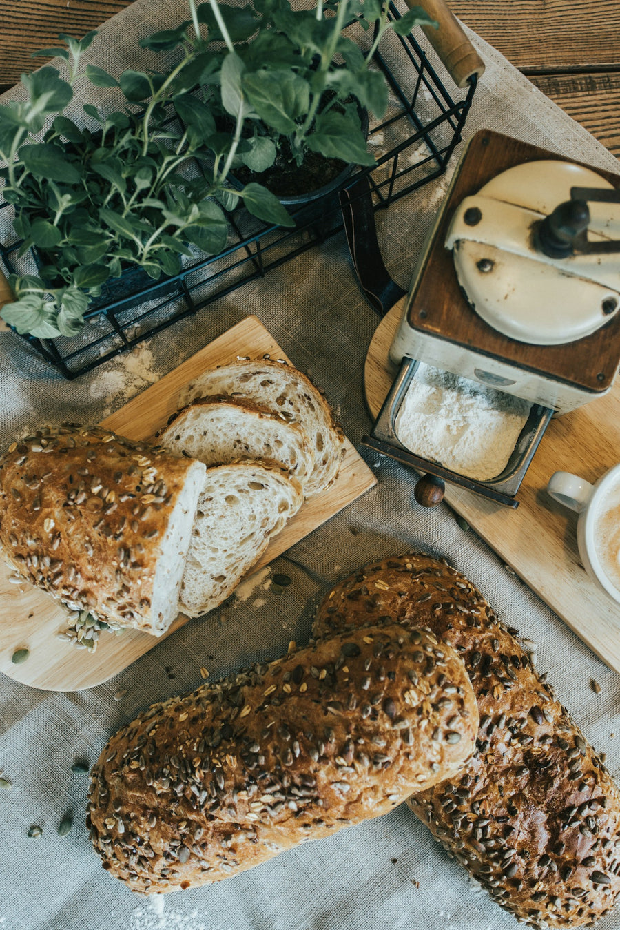 Kerniges Brot mit Saaten, Kräutern und Mühle als stimmungsvolles Bild für Sportlerbrot und Proteinbrot