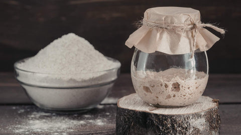 Sauerteig und Mehl im Hintergrund