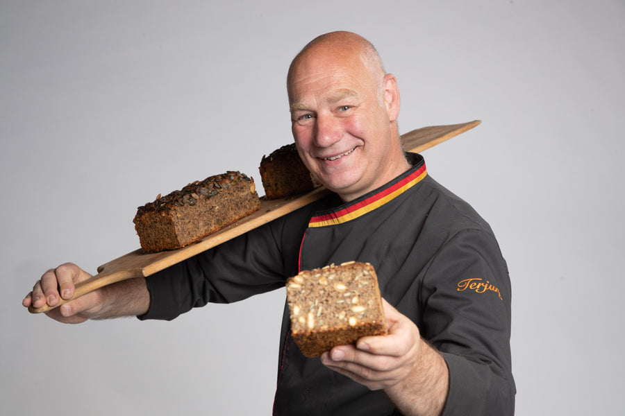 Jörg Terjung hält ein Brot in der Hand